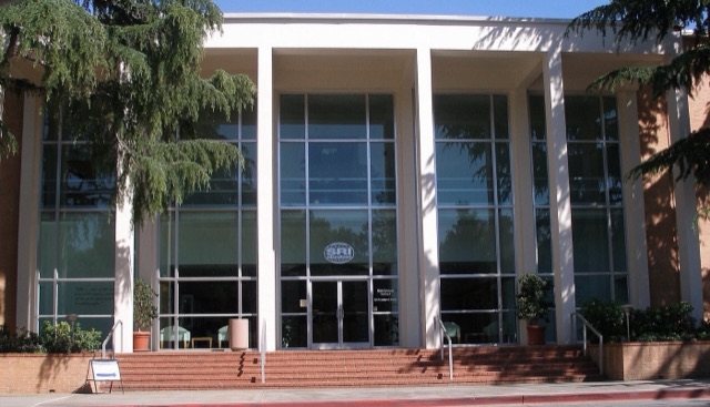 Glass-fronted entrance of a mid-century building with a brick staircase and an SRI International sign
